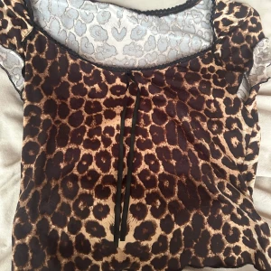 Leopardmönstrad t-shirt med knyt - Säljer en snygg t-shirt med leopardmönster i bruna och beige toner. Använd ett par fåtal gånger, storlek s men passar xs också💕