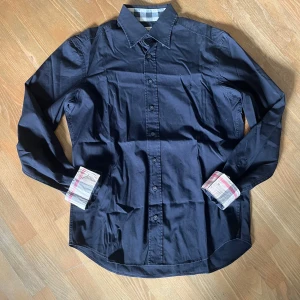 Burberry skjorta - Säljer en svart burberry skjorta i riktigt fint skick. Storlek Medium