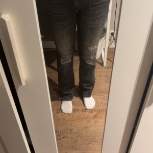 Svarta/gråa bootcut jeans från LTB - Snygga svarta jeans från LTB, modell Valerie. Bootcut passform med slitningar på knäna och klassiska bakfickor. Jeansen har en mörk tvätt och är tillverkade i stretchig denim för en bekväm känsla. De är i storlek 29/32. Väldigt eftertraktade jeans.