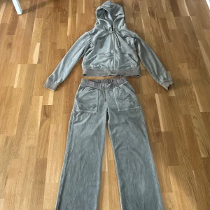 Gröna mjukisbyxor i velour - Gröna mjukisbyxor i mjuk velour med bred resår och snörning i midjan. Byxorna har raka ben och stora fickor framtill. Perfekta för chill dagar eller när du vill vara extra bekväm. Ett litet hål i ena benet och en av metall saken saknas. Byxorna är i XS och tröjan är i M. Jag kunde inte skriva det. Vi kan även diskutera priset💕