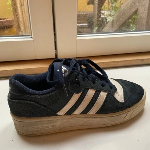 Adidas sneakers i mörkblå mocka - Snygga Adidas sneakers i mörkblå mocka med klassiska vita ränder och detaljer. Knappt använda och super bekväma💕 Storlek 40 men passar även 39 (tveka inte att skriva om ni har frågor) Nypris på Zalando 1245 kr