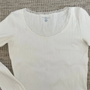Vit långärmad topp från Brandy Melville - Säljer en söt vit långärmad topp från Brandy Melville. Nästan aldrig kommit till användning!💗