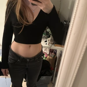 Svart croppad tröja med v-ringning - Säljer en stilren svart croppad tröja med v-ringning och långa ärmar. Perfekt för en trendig look. Passar bra till både jeans och kjol. Hör av dig vid intresse!