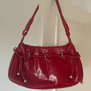 Röd axelväska i skinn - Sparsamt använd!! Vääldigt rymlig +dragkedja och innerfack x3