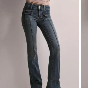 Blå bootcut jeans - Snygga blå bootcut jeans med låg midja och dubbla knappar fram. Fråga vid fler bilder eller funderingar.