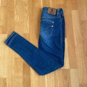 Blå jeans från Dondup - Snygga blå jeans från Dondup med en klassisk femficksdesign och läderpatch med logga baktill. De har en slim passform och är perfekta för en stilren look. Dragkedja och knapp framtill.