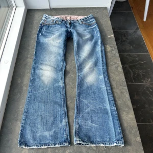 Vintage jeans med slitningar  - Så himla coola jeans med slitningar. Lågmidjade. Har tyvärr ingen bild på då de inte passar. Innerbenslängd: 73 cm  midjemått: ca 40 cm midjehöjd: 18 cm. Skriv till mig om ni vill ha bilder på exakt hur jag har mätt, då alla kan mäta lite olika.💕