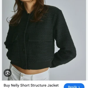 Svart kort jacka från Nelly - Snygg svart kort jacka från Nelly med struktur. Jackan har långa ärmar och knappar framtill. Lite cropad i modellen 🥰 Endast använd en gång 