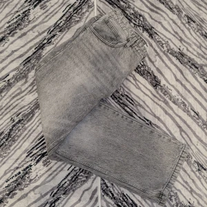 Grå jeans från Bershka - Snygga grå jeans från Bershka med en klassisk femficksdesign. De har en straight passform och är perfekta för en avslappnad stil. Jeansen har en dragkedja och knapp framtill. Den är baggy men passar riktigt bra! Kan diskuteras om ett bra pris den är i baggy form.