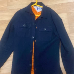 Mörkblå jacka från Jones New York - Snygg mörkblå jacka från Jones New York med knappar framtill och två bröstfickor. Jackan har en klassisk krage och är långärmad. Perfekt för en stilren look. 170 164