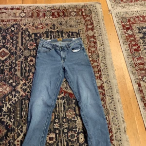 Blå jeans från Jack & Jones - Snygga blå jeans från Jack & Jones med klassisk femficksdesign. De har en normal passform och är tillverkade i slitstarkt denim. Perfekta för en avslappnad stil. Och den är 176 cm storlek