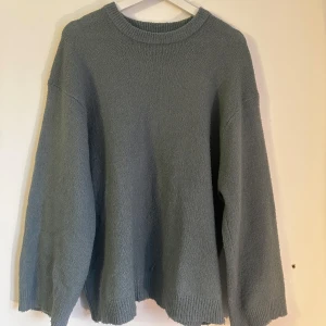 Grå stickad tröja - Mysig blå/grön tunn stickad tröja med rund hals och långa ärmar. Perfekt under både tjockare och tunnare jacka.