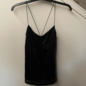 Svart glitter/paljett top - Snyggt svart linne från Gina Tricot med tunna axelband. Den är perfekt till nyår eller nån annan fest kanske💕