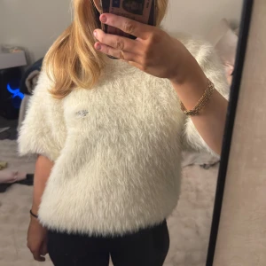 Vit fluffig tröja - Säljer en supermjuk och fluffig vit tröja med korta ärmar. den här fått ett hål då säljer den vidare som kan ge den mer kärlek!! nypris 500 men billigare pga hålet