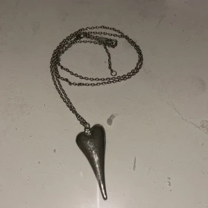 Silverfärgat halsband med hjärta - Snyggt silverfärgat halsband med ett unikt, avlångt hjärta som hänge. Kedjan är tunn och lång.💖