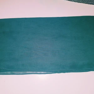 Turkos sjal från Collection - Säljer en tunn och luftig turkos sjal från Collection. Sval och lätt, perfekt att slänga över axlarna. Rektangulär form och enfärgad design gör den enkel att styla till olika outfits.  Helt & fint skick