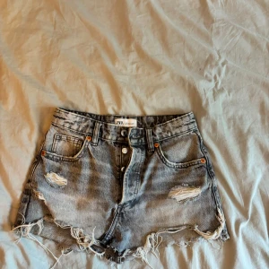 Grå jeanskjol  - En super snygg grå jeanskjol med slitningar!! Denna kjol är från början ett par shorts ifrån Zara men som jag nu sytt om💘 kjolens gylf består av fyra knappar och är hyfsat liten i sin storlek, när kjolen var shorts så har jag använt de kanske 3 gånger och som kjol är den aldrig använd🩷 (se bilderna på hur den är omsydd)