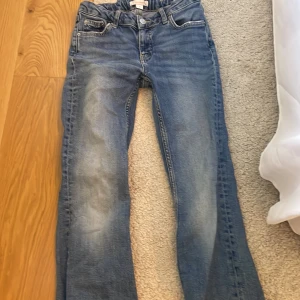 Blå utsvängda jeans - Midwaist jeans från gina tricot. Har blivit lite urtvättade men fortfarande i bra skick. Byxorna ser ut att vara raka på bild men är utsvängda.