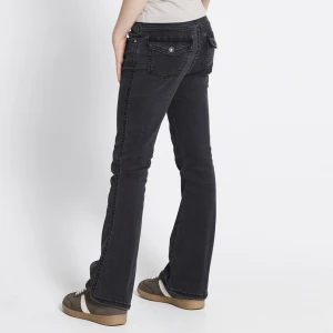 Svarta jeans - Snygga svarta jeans med bootcut passform och coola fickor med lock och knapp bak. Mjukt denimtyg som sitter skönt hela dagen. Lite slitna längst ner på jeansen men inget man tänker på. Fråga om bild om du en intresserad💗