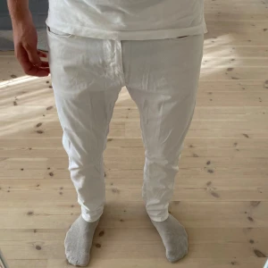 Vita slim fit byxor från Massimo Dutti - Snygga vita slim fit byxor från Massimo Dutti med klassisk femficksdesign. Byxorna är tillverkade i ett mjukt bomullstyg med diskret struktur och har normal midja. Perfekta för en clean och fräsch look.