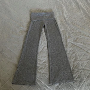 Grå mjukisbyxor från Gina Tricot -  Supersnygga grå mjukisbyxor från Gina Tricot, barnstorlek 134/140! Med hög midja och coola utsvängda ben i supermjukt, stretchigt material — perfekta för alla som vill ha comfort med en trendig retro-touch. Mjukisbyxorna som gör chilldagen till en stilboost! Missa inte, en riktig favorit för den lilla fashionistan. 