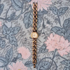 Guldfärgad länk-klocka från O.N.E - Stilren guldfärgad klocka från O.N.E med klassisk länkarmband och rund urtavla. Urtavlan är ljus med minimalistiska guldiga markeringar och visare. Boetten är i metall och baksidan i rostfritt stål. Perfekt accessoar för dig som gillar tidlös design.