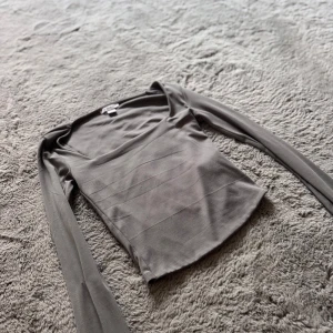 Grå långärmad topp från Missguided - Säljer en grå topp som är långarmad och mer öppen i bröstkorgen. Den är köpt från Mew yorker och bara använd några par gånger.