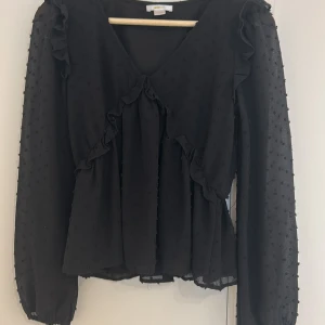 Svart blus med V neck. - Det här är den perfekta blusen om du vill ut på stan, resturang eller vart som helst. Tröjan sitter bra, passar ung som xs. Säljer den eftersom jag använder den inte.