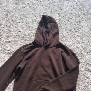 Brun hoodie från H&M Relaxed Fit - Mysig brun hoodie från H&M i relaxed fit. Tröjan har huva, lång ärm och en klassisk känguruficka framtill. Inte använt mycket pågrund av färgen☺️