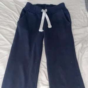 Mörkblå mjukisbyxor från russemerch XXS - Mörkblå mjukisbyxor i storlek XXS med vita snören i midjan och två fickor. Perfekta för chill dagar eller när du vill vara extra bekväm. Mjukt material och klassisk passform.