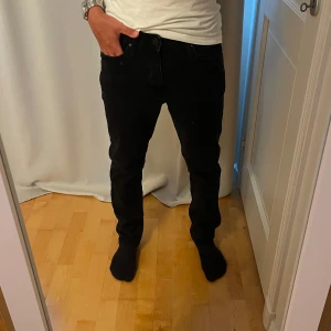 Svarta jeans Jack & Jones Clark - Svarta jeans från Jack & Jones, modell Clark Regular. Klassisk femficksdesign, rak passform och normal midja. Jeansen är tillverkade i bomull med en snygg mörk tvätt och subtila detaljer. Perfekta för en clean och stilren look. Knappt använda, i princip nya! 