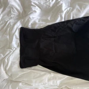 Svart kort klänning från NA-KD, stl 36 - Säljer en svart kort klänning från NA-KD i storlek 36. Klänningen har en stilren och enkel design med rak passform, perfekt för dig som gillar minimalistiska vibes. Materialet känns mjukt och följsamt, vilket gör den superbekväm att bära.