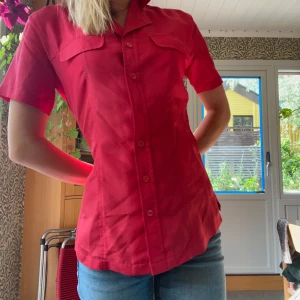 Röd, kortärmad silkesskjorta  - Häftig skjorta från Kappahl som enkelt kan spicya upp en outfit🌶️! Jättesnygg röd färg och lite större i storleken; lite lös på mig som är en S i vanliga fall (men den är storlek 34). Är hyfsad figursydd runt midjan men större vid ärmarna och byst🍒 Jättesnygg men kommer tyvärr ej till använding:/ 100% silke
