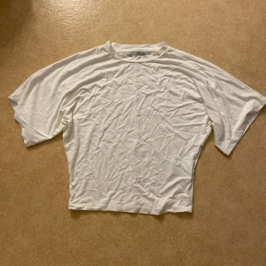 Tröja - Kortärmad tröja som är större i ärmarna och tajtare i midjan.