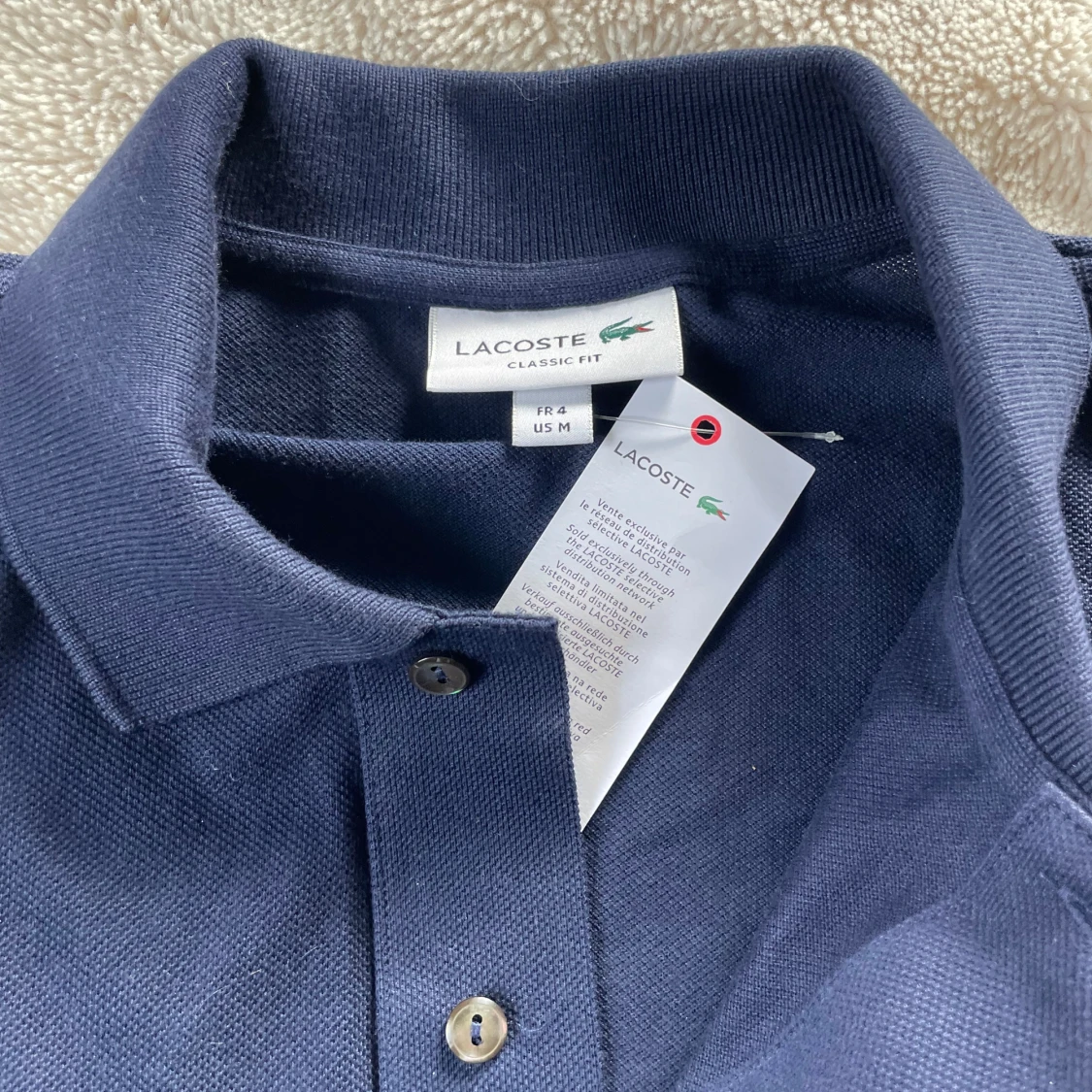 Mörkblå pikétröja från Lacoste