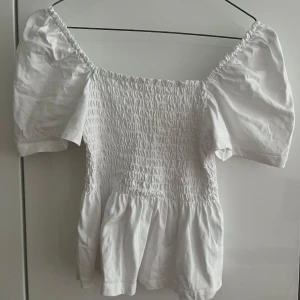 Superfin vit top - Supersöt vit blus med smockad överdel och vackra puffärmar. Passar perfekt med jeans eller kjol. Meddela mig ifall du är intresserad. 💕💕