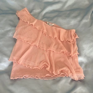 Rosa volangig oneshoulder topp - Supersöt rosa oneshoulder topp från Cubus perfekt till sommaren aldrig använd ba testad men kommer inte till användning 