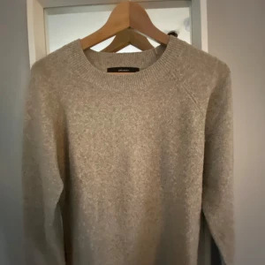 Beige stickad tröja från Vero Moda - Mysig beige stickad tröja från Vero Moda med rund halsringning och långa ärmar. Perfekt för lager-på-lager och enkel att matcha med jeans eller kjol. Tröjan har en klassisk, avslappnad passform och ribbade muddar vid halsen. Står ej för postens slarv Köpt är köpt, gär ej att returneras. Pris går att diskuteras