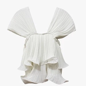 Vit plisserad blus med volanger - Superfin vit blus med breda axelband och plisserat tyg. Toppen har dubbla lager med vågiga volanger. 