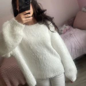 Vit fluffig stickad tröja - Världens mysigaste vita stickade tröjan med fluffigt garn och oversized passform. Tröjan har långa ärmar och en enkel rund halsringning. Perfekt för att hålla sig varm och ändå se stilren ut. Passar dig som gillar en chill och cozy vibe. Pris kan diskuteras 💕