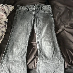Grå jeansbyxor från H&M Divided, strl 42 - Snygga grå jeansbyxor från H&M Divided i storlek 42. De har klassisk femficksdesign, bootcut och en cool tvättad look. Köpte för 300kr och säljer för har aldrig blivit använda