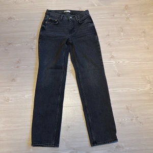 Svartgråa low straight jeans från ginatricot  - Snygga svårtgråa low waist jeans med en rak passform i storlek 34. Fint skick, använda fåtal gånger