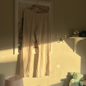 Beige ribbade byxor Brandy Melville - Säljer ett par ljusbeige ribbade byxor från Brandy Melville. Byxorna har elastisk midja och är raka i modellen med en skön, loose passform. Perfekta för en chill och avslappnad stil. Materialet känns mjukt och luftigt.