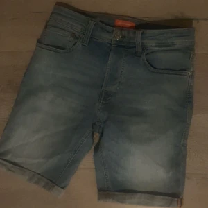Blå jeansshorts från Jack & Jones XS - Snygga blå jeansshorts från Jack & Jones i klassisk femficksmodell. Shortsen har uppvikta benslut, normal passform och är tillverkade i mjukt denim. Perfekta för varma dagar och en avslappnad stil. Storlek XS.
