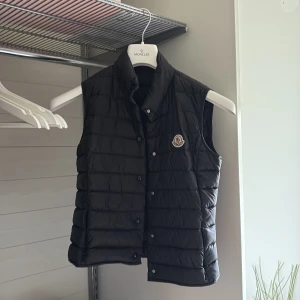 Svart dunväst från Moncler - Sååå snygg svart dunväst från Moncler! Storlek dam 1 vilket motsvarar ungefär S/XS❤️ självklart äkta, köpt i Stockholm för 5 år sen❣️ superbra skick, som ny🥰 säljs då den tyvärr inte kommer till användning längre 💕💕dustbag o kvitto ingår