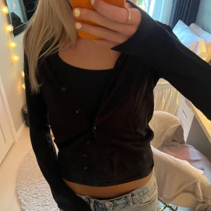 Svart kofta med knappar - Säljer en svart, figurnära kofta med långa ärmar och knappar framtill ifrån H&M. Enkel och stilren modell som passar perfekt till jeans eller kjol. Koftan är i ett mjukt material och har en klassisk look.