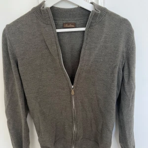 Stenströms tröja  - Snygg oliv grön kofta från Stenströms i 100% merinoull . Modellen har ribbade muddar, hög krage och hel dragkedja framtill.  Perfekt för lager-på-lager och funkar året runt. Enkel och stilren design som passar till det mesta. Storlek small