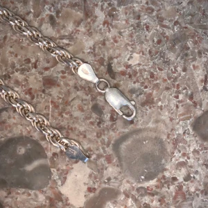 Tjockt silverhalsband i repkedja - Säljer ett snyggt halsband i äkta silver med repkedja. Kedjan har en cool, tvinnad design och är markerad med 925-stämpel. Perfekt för dig som gillar stilrena och tidlösa smycken. Lås med karbinhake för extra säkerhet. 50-55 cm BUDA