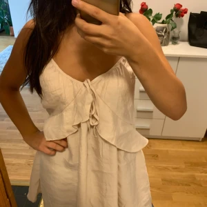 Ljus kortklänning med volang och snörning (pris kan diskuteras) -  (Pris går att diskuteras) 