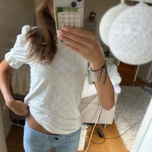 Vit blus med broderade hål och puffärm - Superfin vit blus med trekvartsärm
